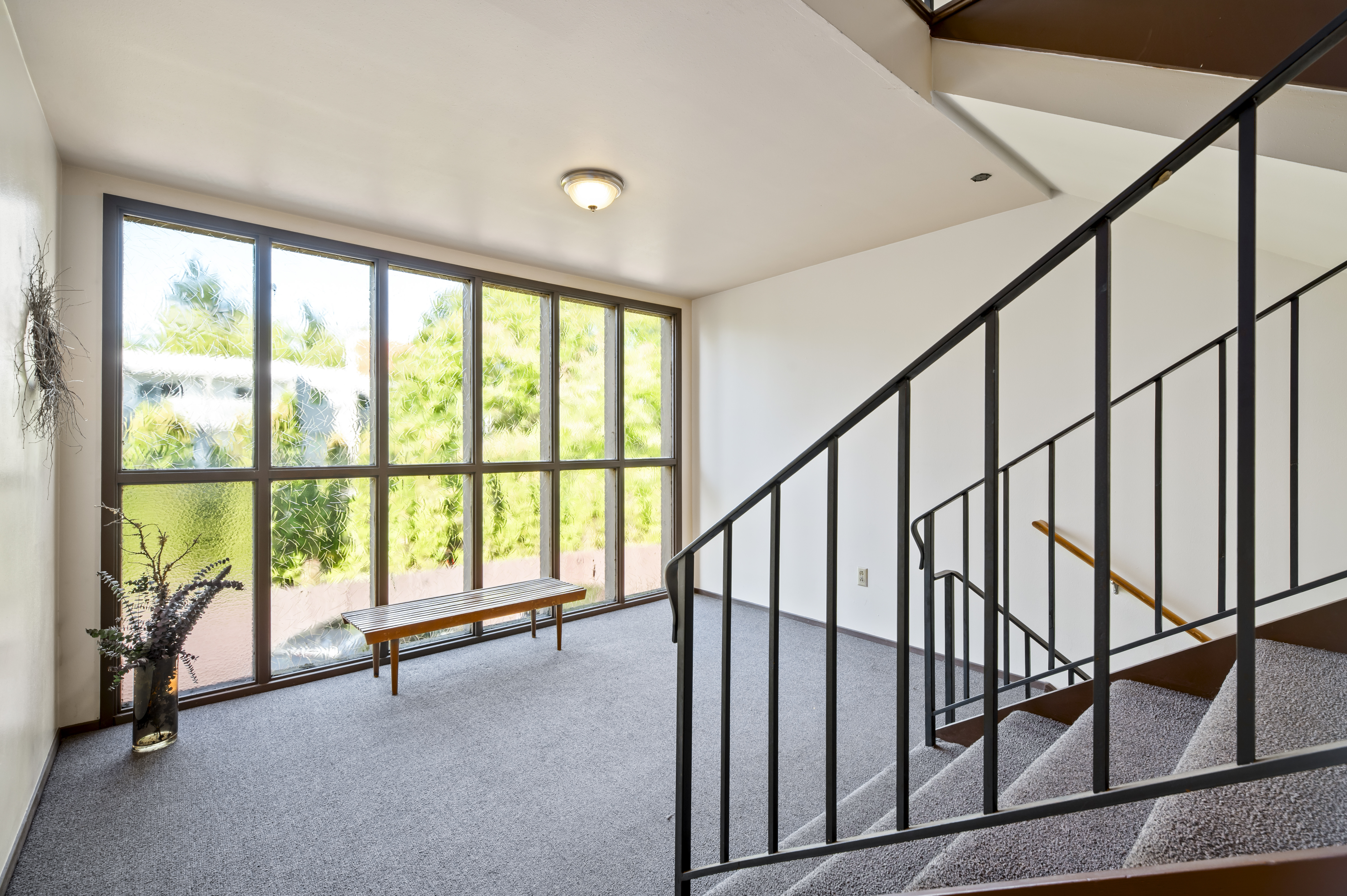 Common-area stairwell before renovation — carpet and dated railing