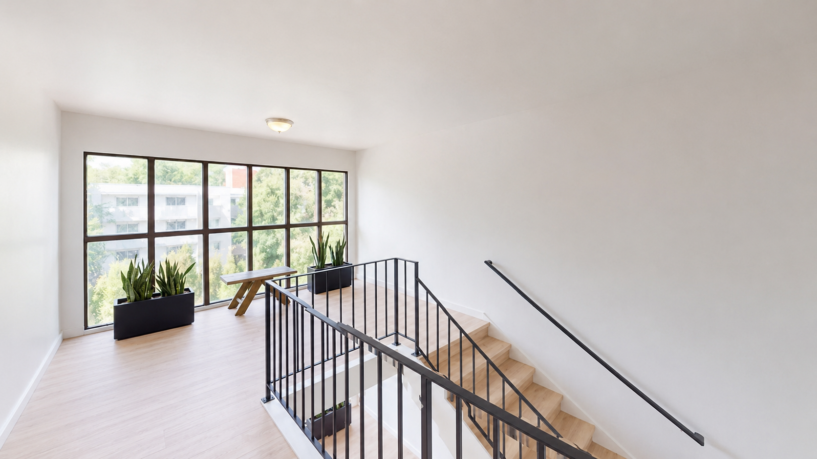Renovated common-area stairwell — wood-look flooring and black railing
